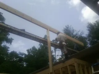 Carpenter setting a ridge beam over a new addition frame — Ice Dam Removal by Roofing Brothers in Pitcairn
