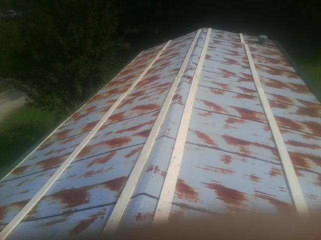 Rusted metal roof panels with new wood purlins before replacement — Storm Damage Roof Repair in Pitcairn by Roofing Brothers