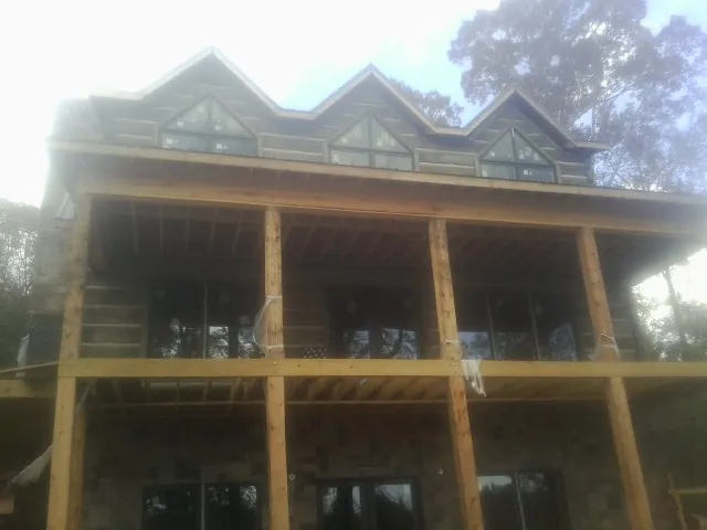 Dormers and porch framing on a large log home under construction — Roof Coating work by our crew in Pitcairn