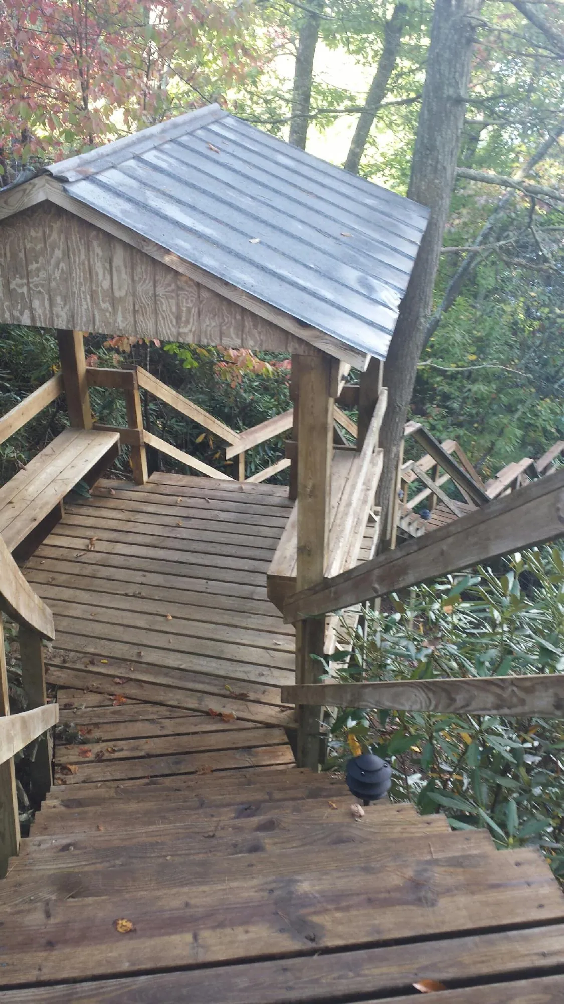 Metal roofed shelter over wooden steps on a wooded walkway — Skylight Repair & Installation work by our crew in Pitcairn