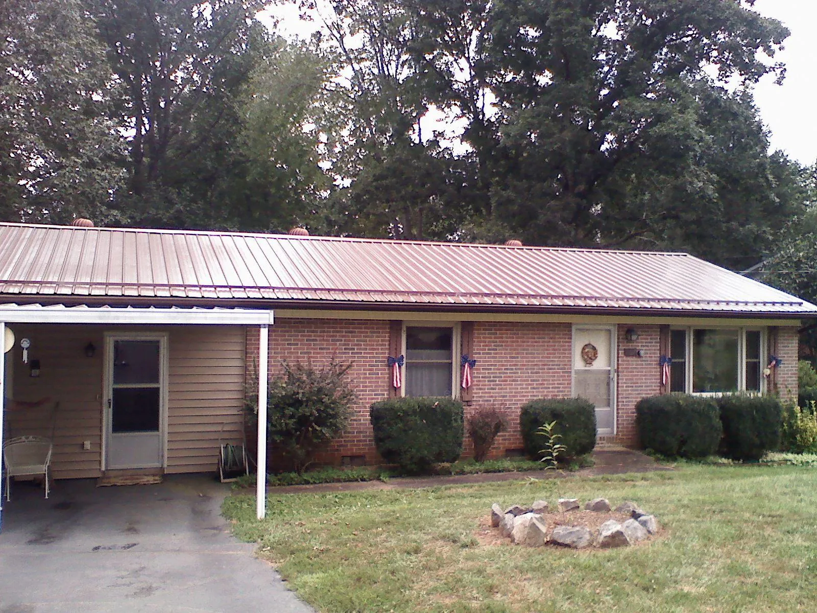 Bronze metal roof and carport on a brick ranch home — Roof Repair work by our crew in Pitcairn